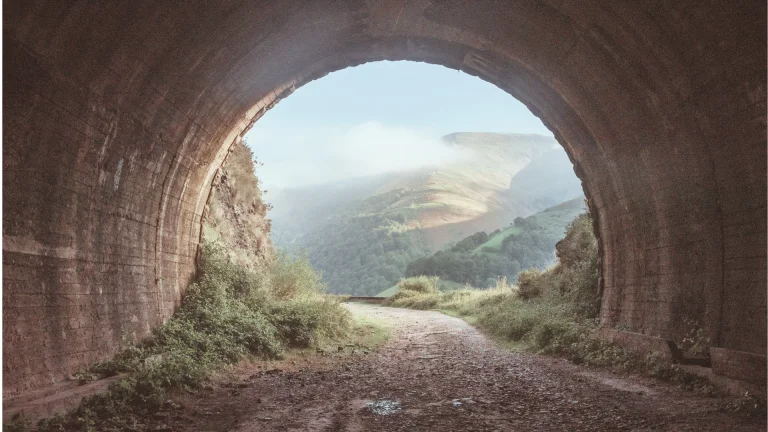 Path through a tunnel towards open countryside, representing moving towards clarity