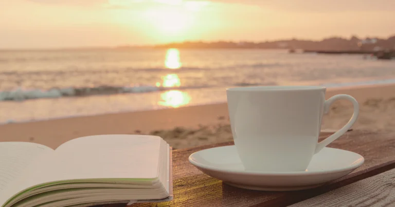 Calming self-help image with coffee and notebook by the water